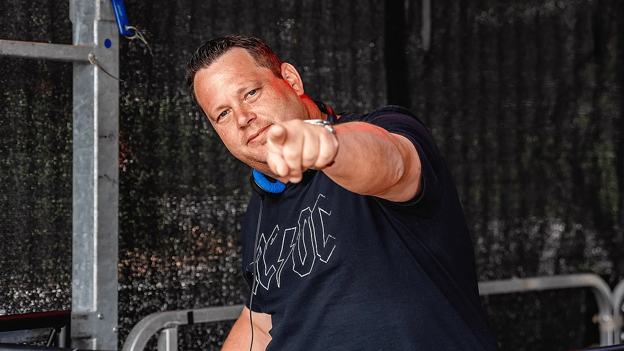 DJ mit Kopfhörern an einem Mischpult während einer Veranstaltung.