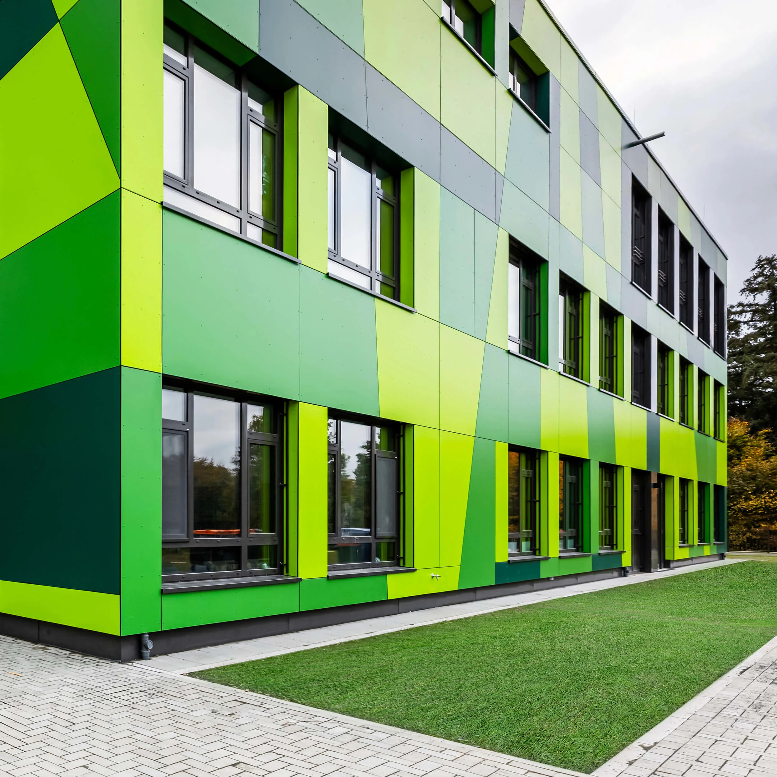 Modernes Gebäude mit auffälliger grüner Fassadengestaltung und großen Fenstern